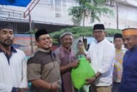 Asisten I Pemkab Kolaka memberi bantuan paket sembako ke warga di Kelurahan Dawi-dawi, Pomala. (Foto: Humas Diskominfo)